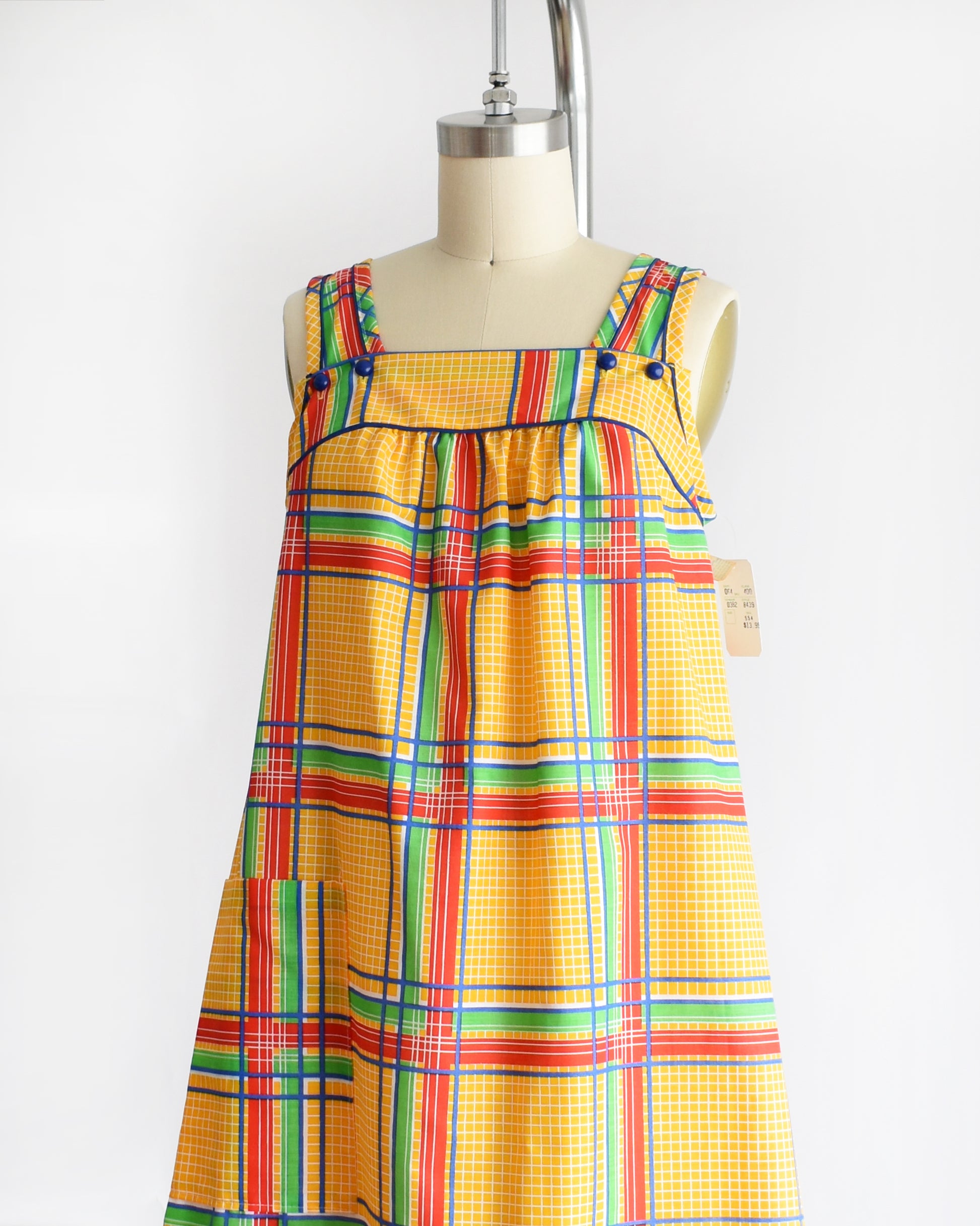 side front view of a vintage 1970s yellow plaid dress on a mannequin against a white background