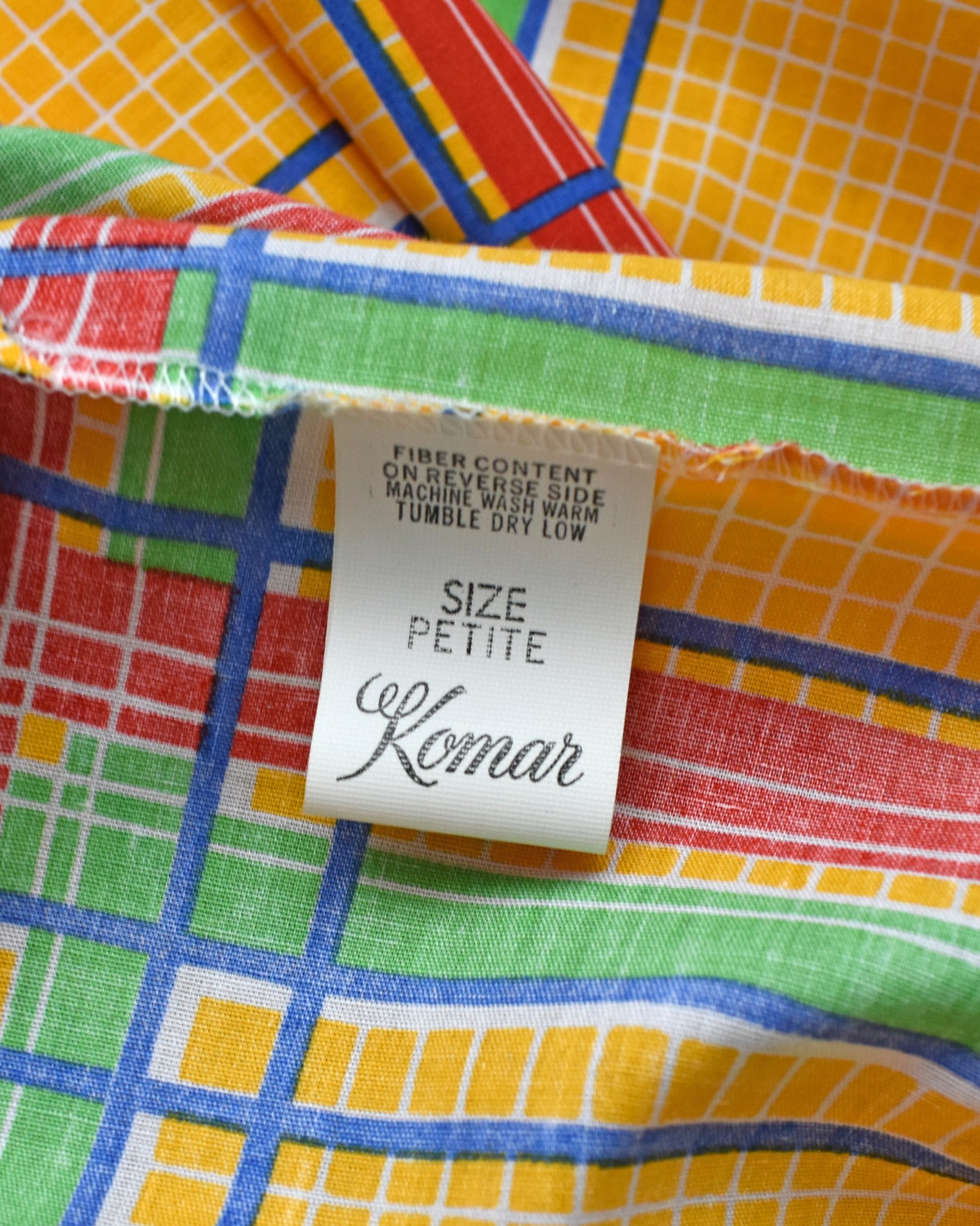Colorful fabric with a Komar label indicating size 'Petite'.