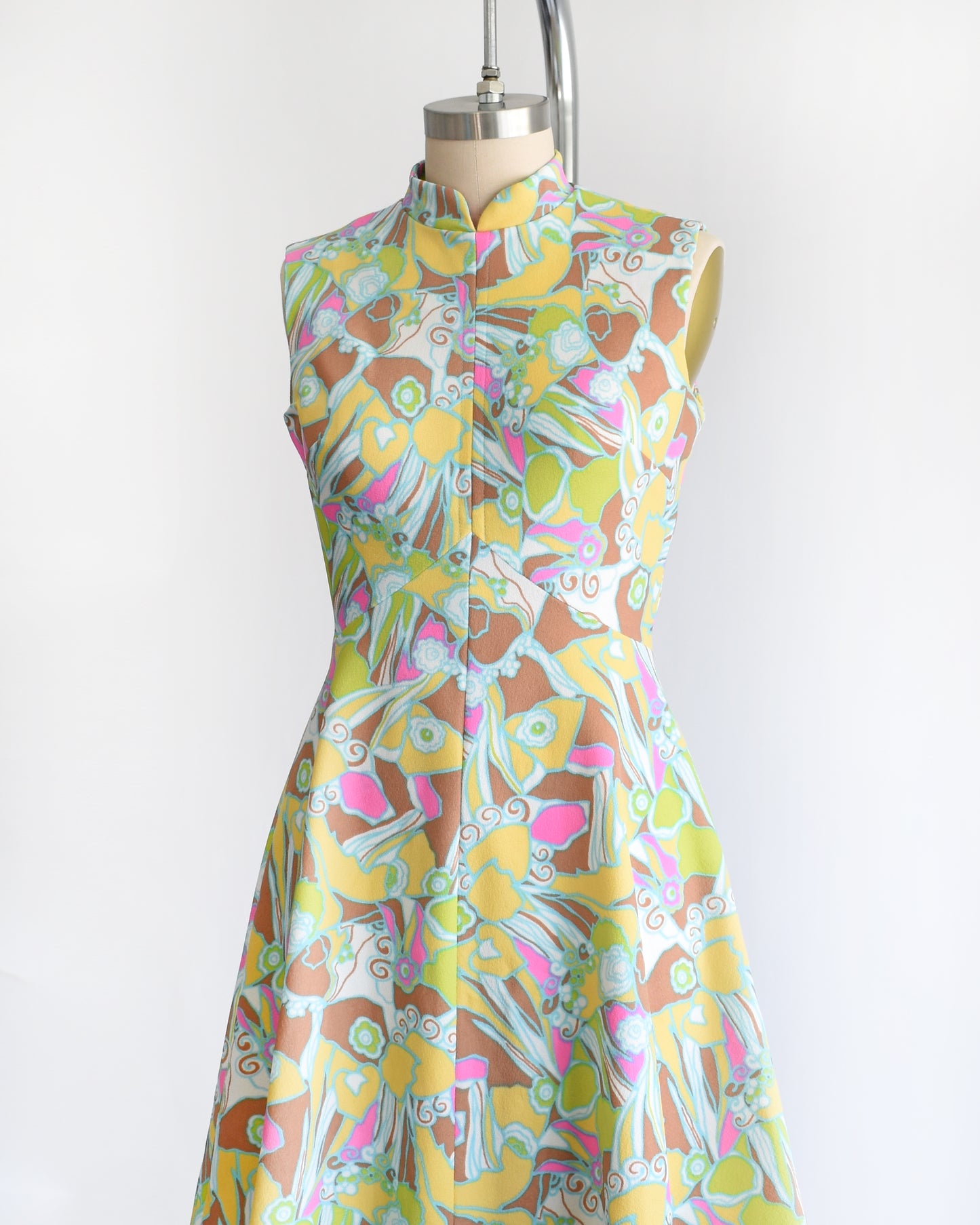 side front view of a vintage 1970s mod colorful floral dress on a mannequin against a white background