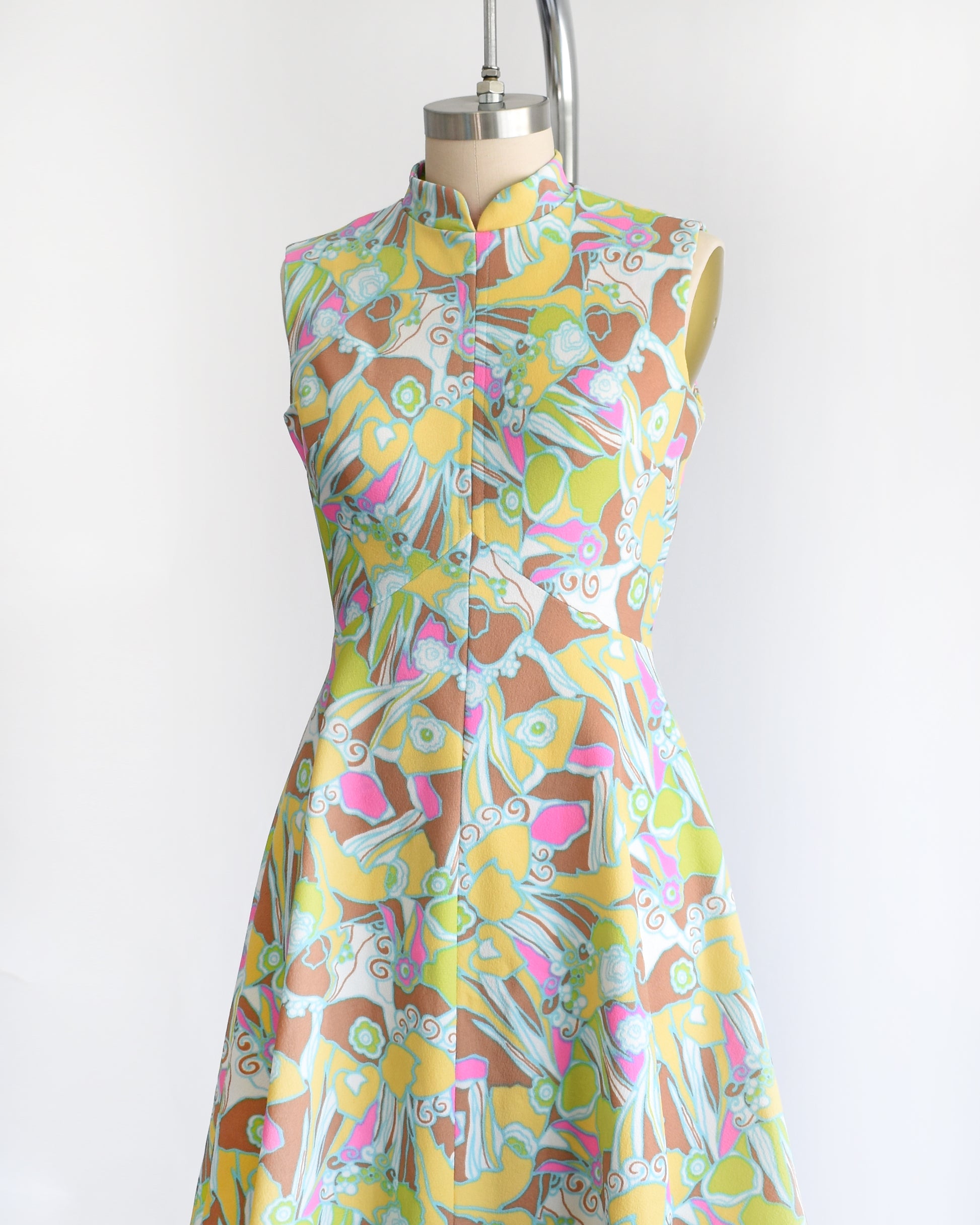 side front view of a vintage 1970s mod colorful floral dress on a mannequin against a white background
