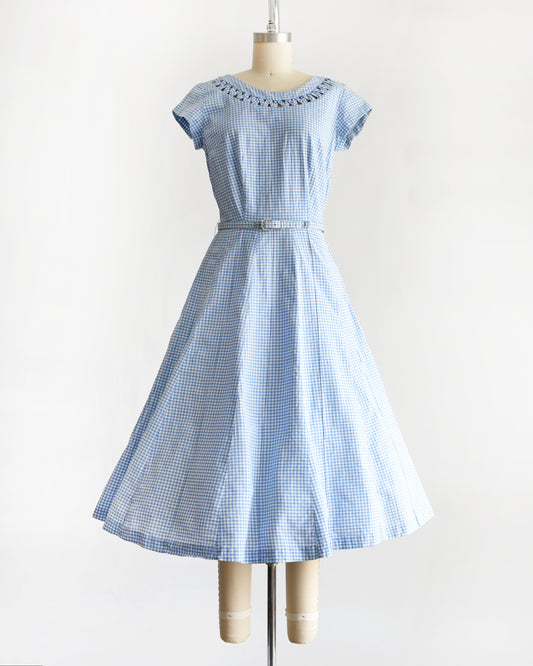 a vintage 1950s blue and white gingham dress on a mannequin against a white background 
