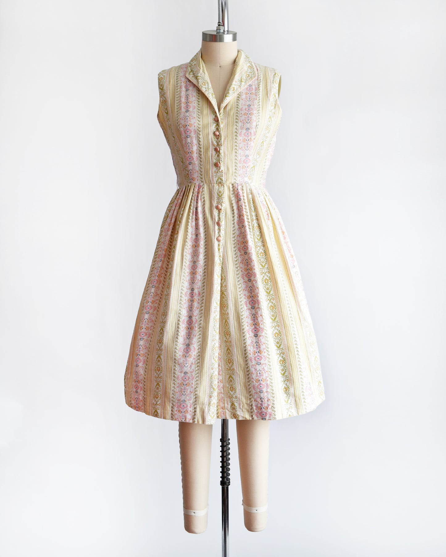 a vintage 1950s dress on a mannequin against a white background