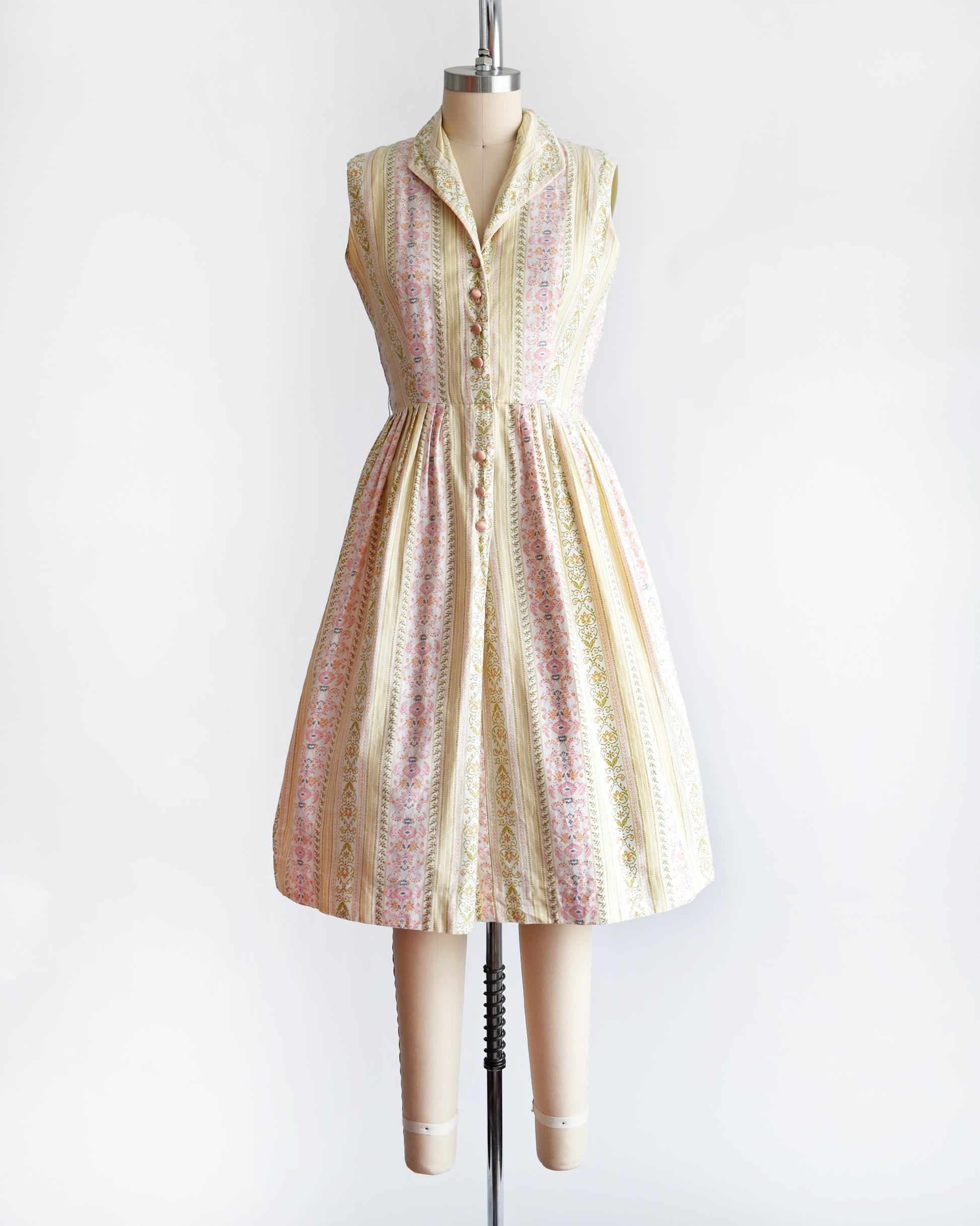 a vintage 1950s dress on a mannequin against a white background