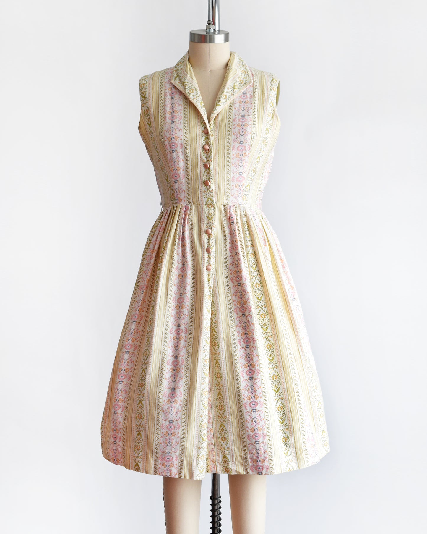 a vintage 1950s dress on a mannequin against a white background