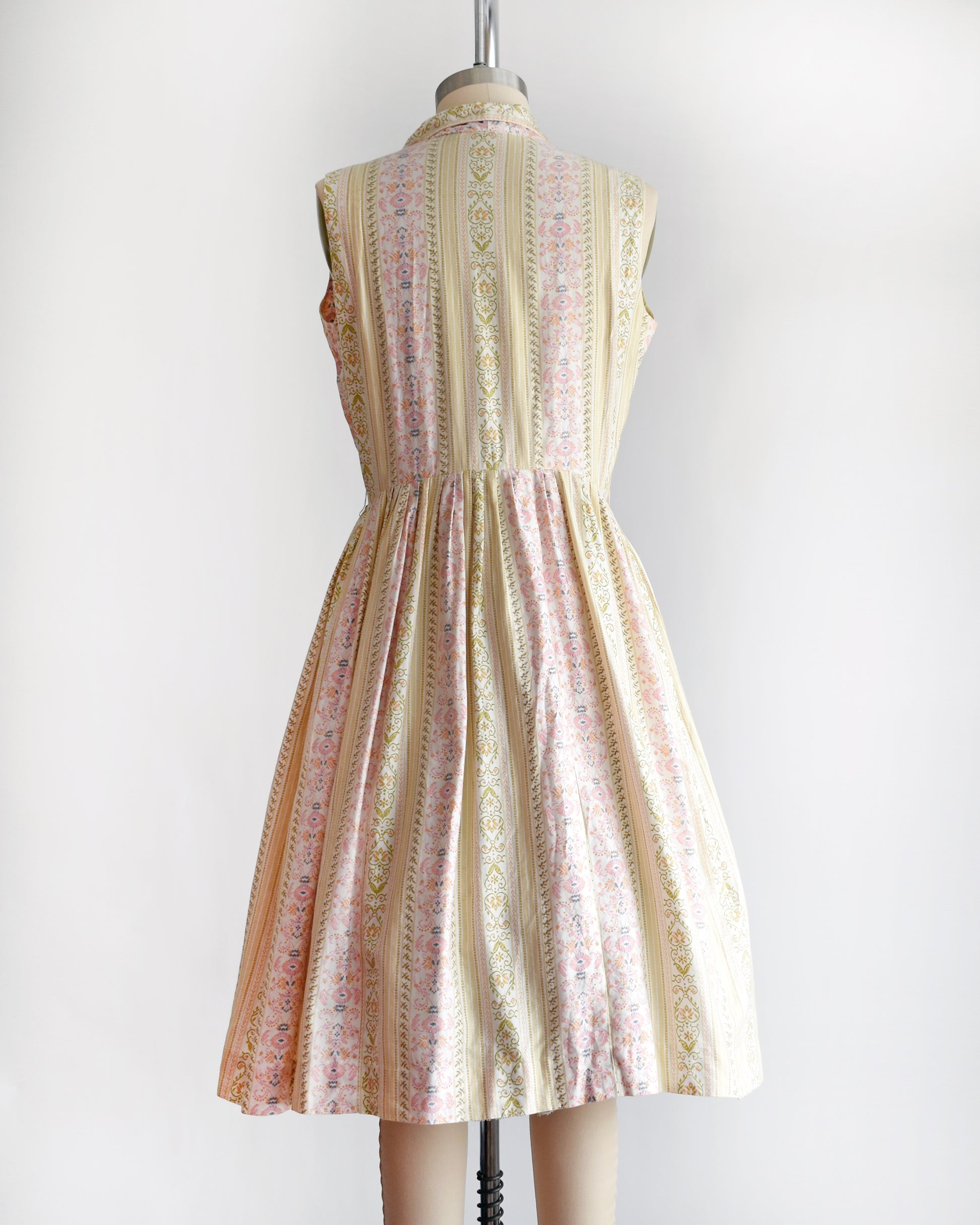 back view of a vintage 1950s dress on a mannequin against a white background