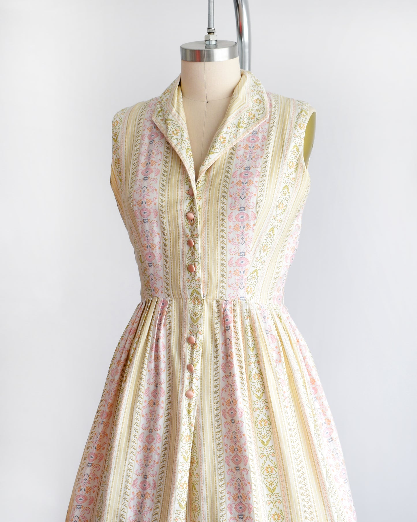 side front view of a vintage 1950s dress on a mannequin against a white background