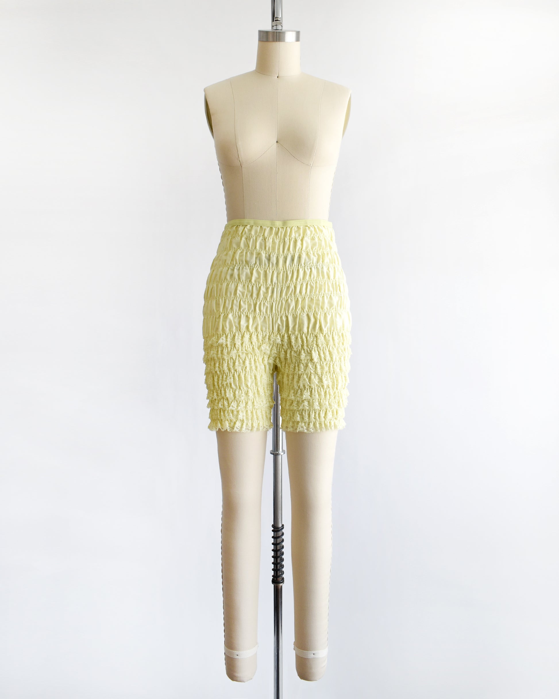 vintage yellow ruffled shorts on a mannequin against a white background