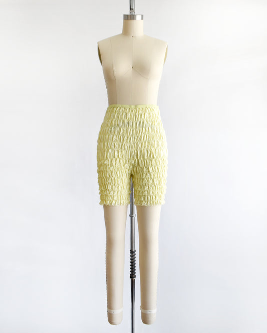 vintage yellow ruffled shorts on a mannequin against a white background
