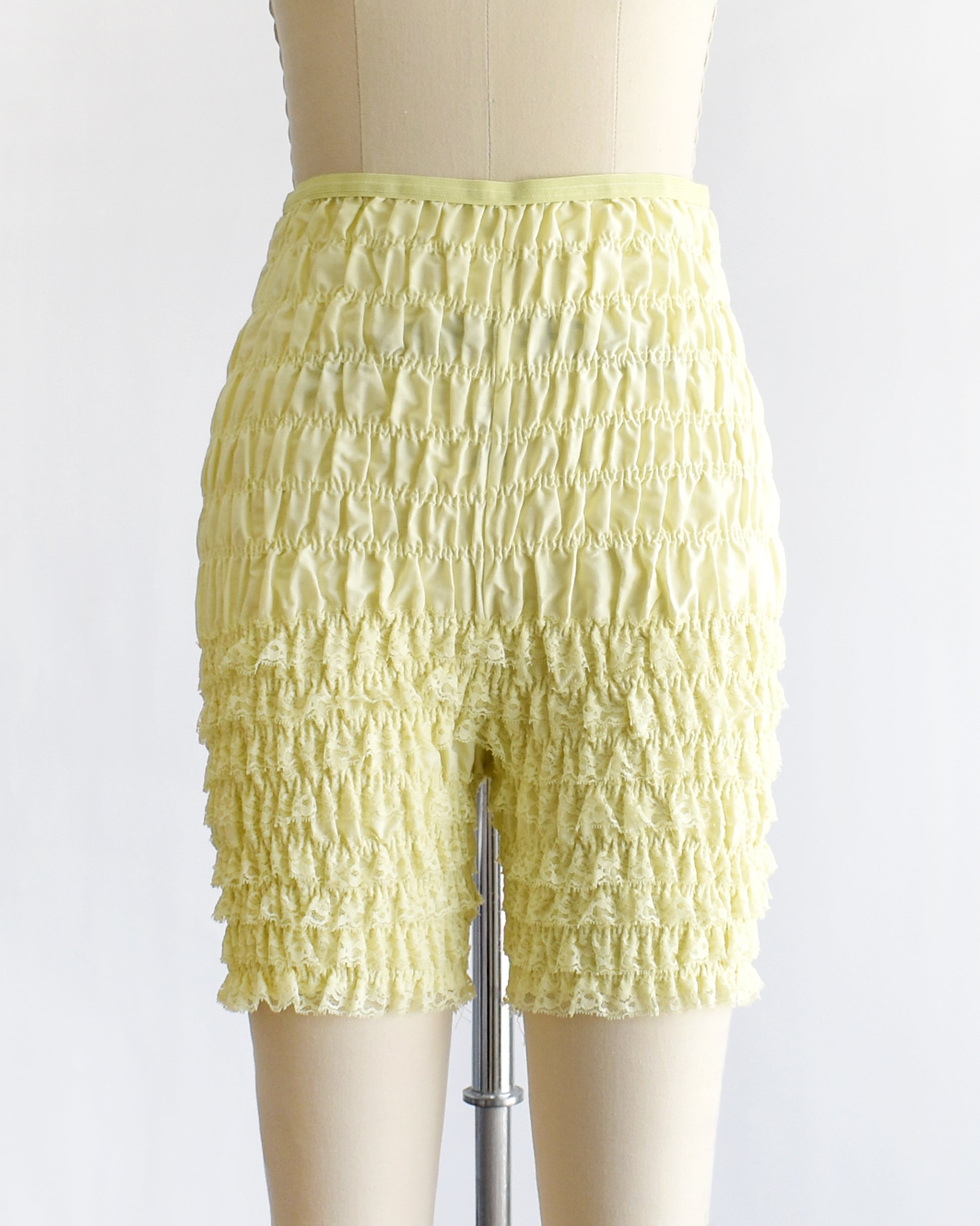 vintage yellow ruffled shorts on a mannequin against a white background