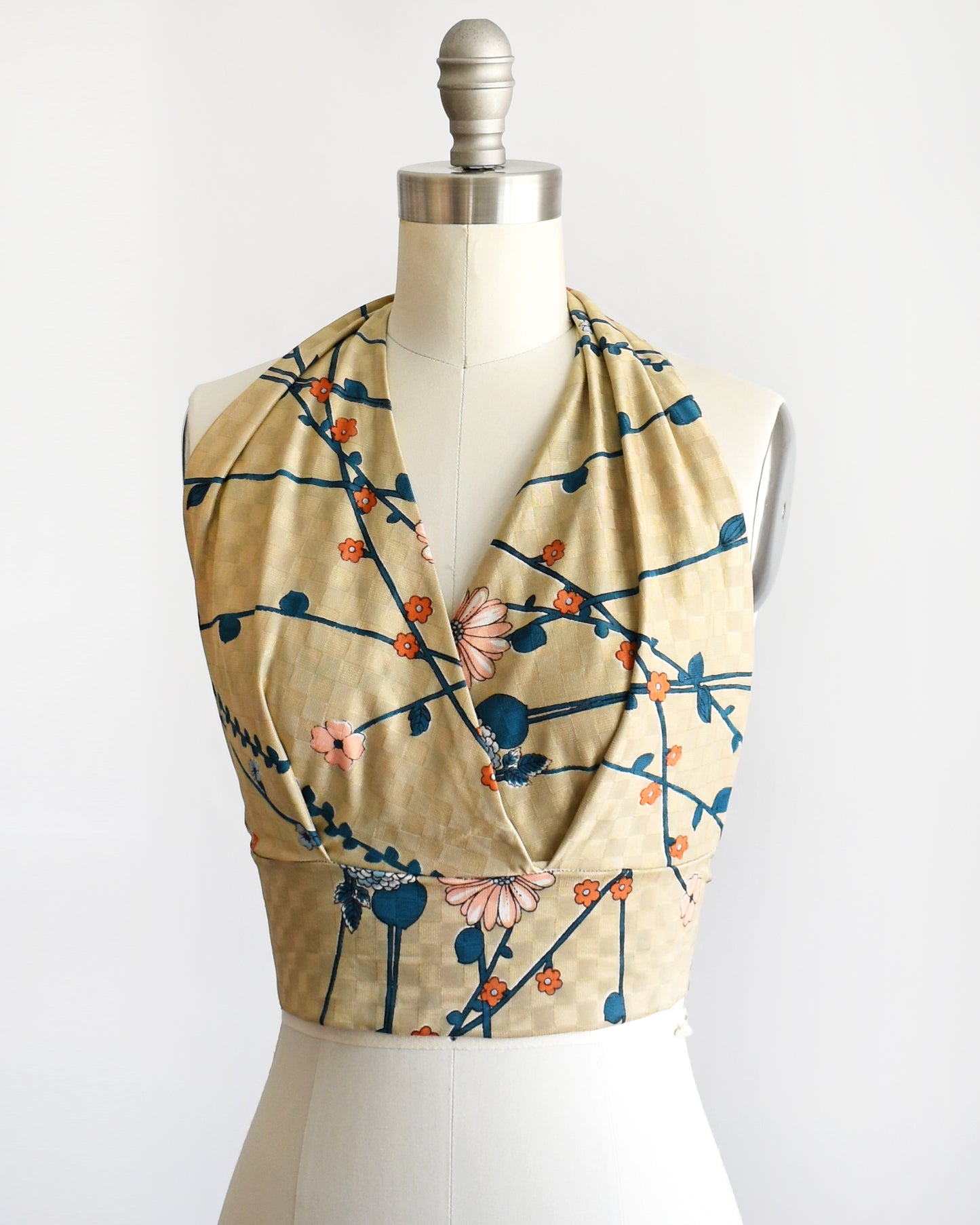 side front view of a vintage 1970s floral halter top on a dress form