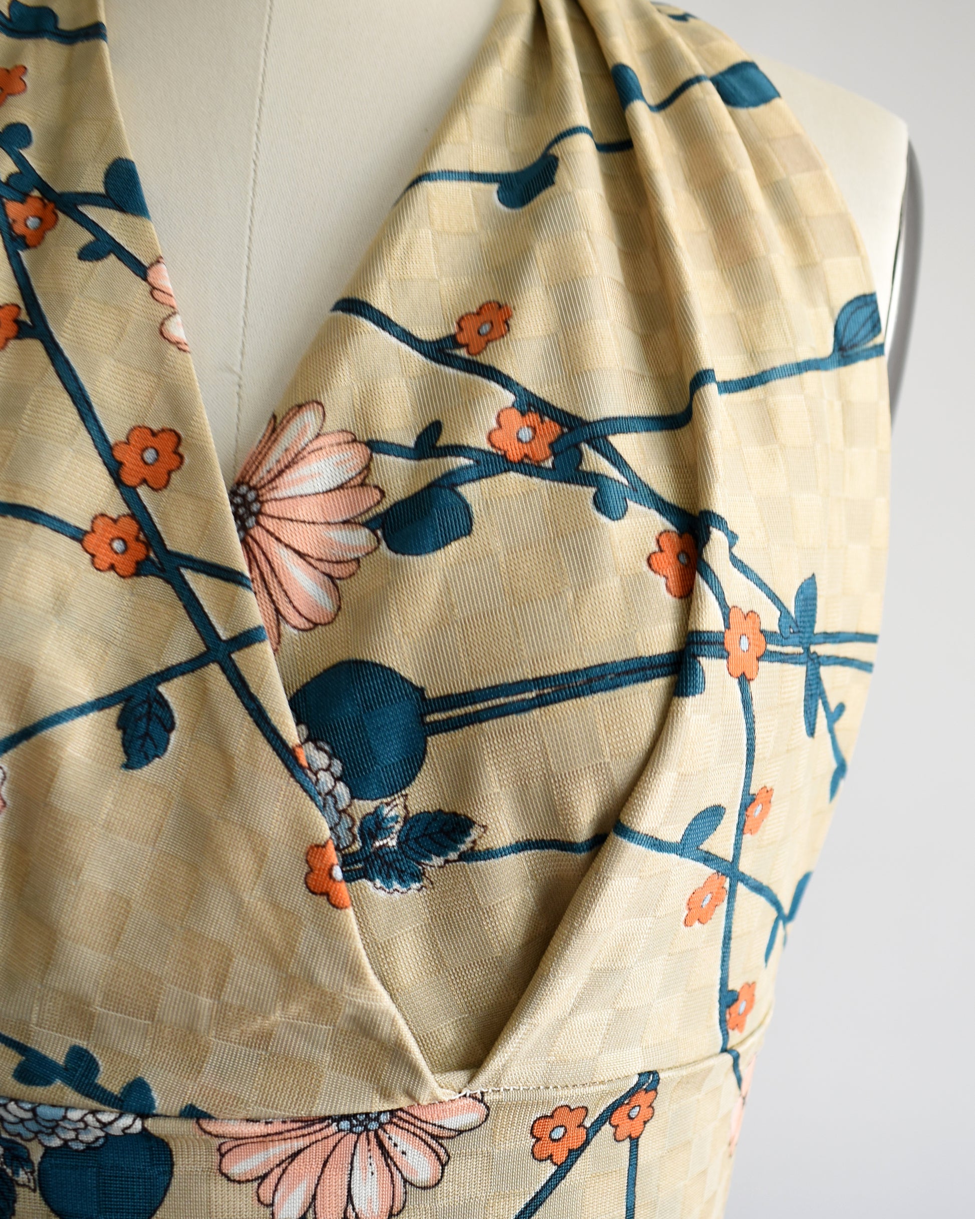 close up a vintage 1970s floral halter top on a dress form