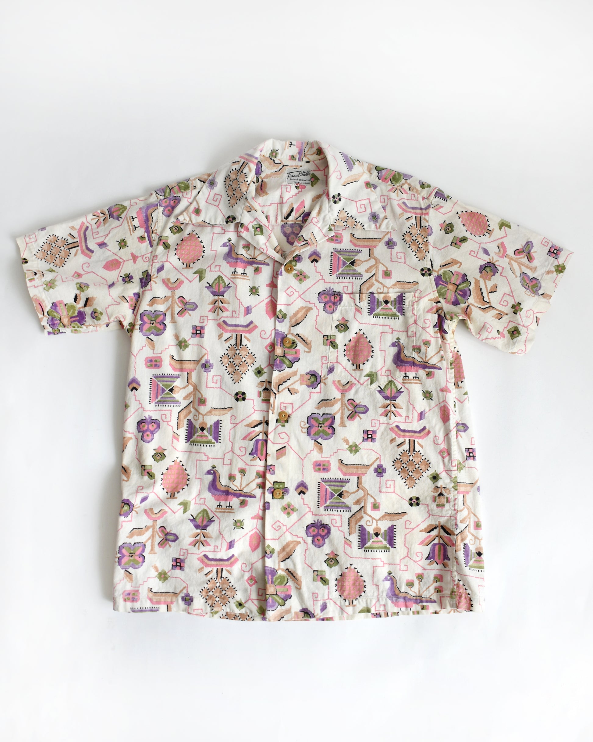a vintage 1950s Tiana Pittelle short-sleeve Hawaiian aloha shirt with a colorful pattern on a white background