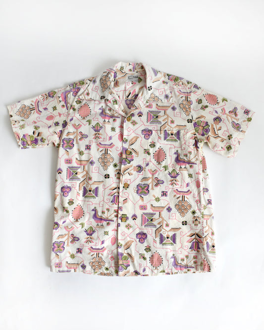 a vintage 1950s Tiana Pittelle short-sleeve Hawaiian aloha shirt with a colorful pattern on a white background