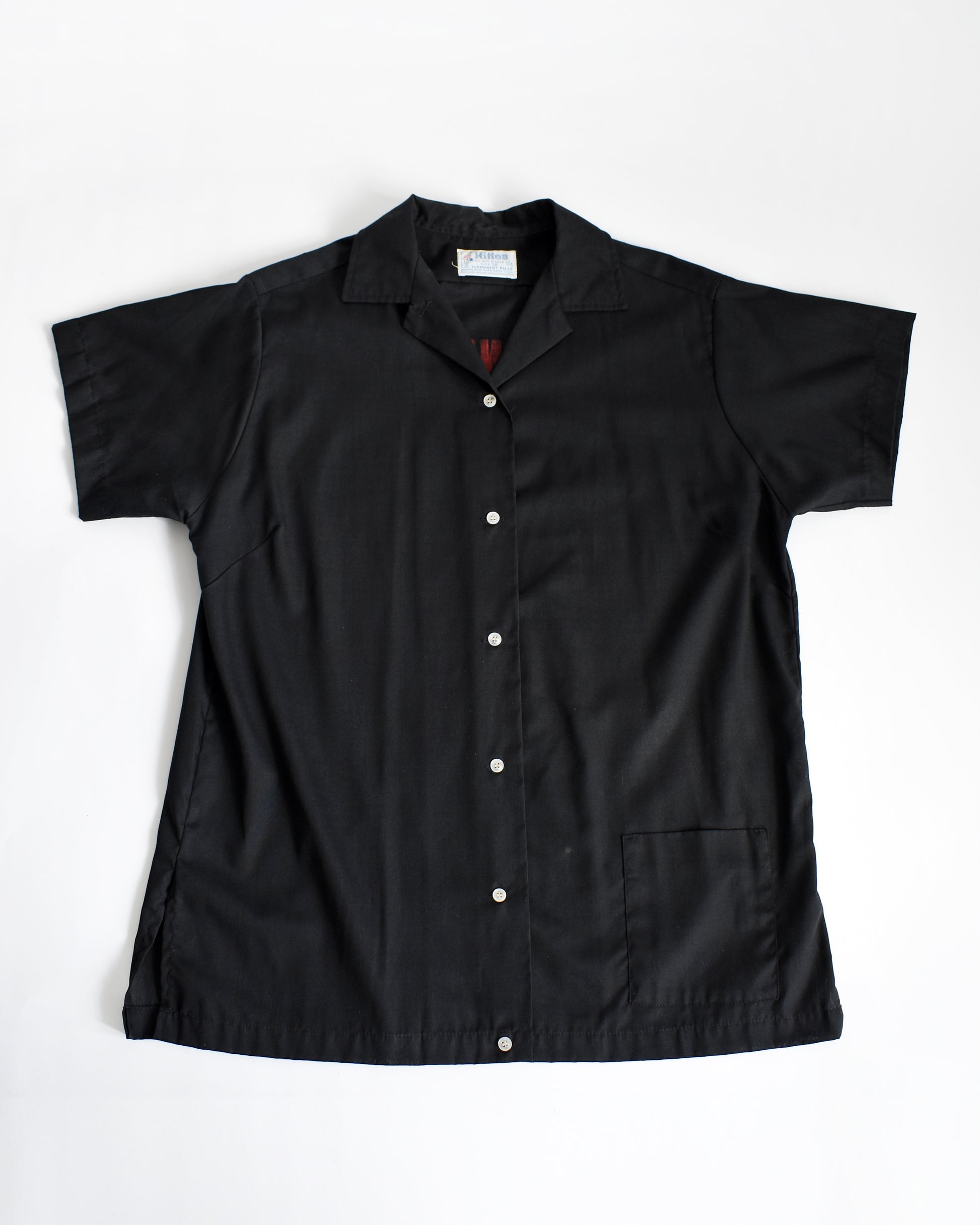 a vintage 1970s black bowling shirt on a white background