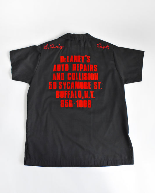 a vintage 1970s black bowling shirt with red lettering on a white background