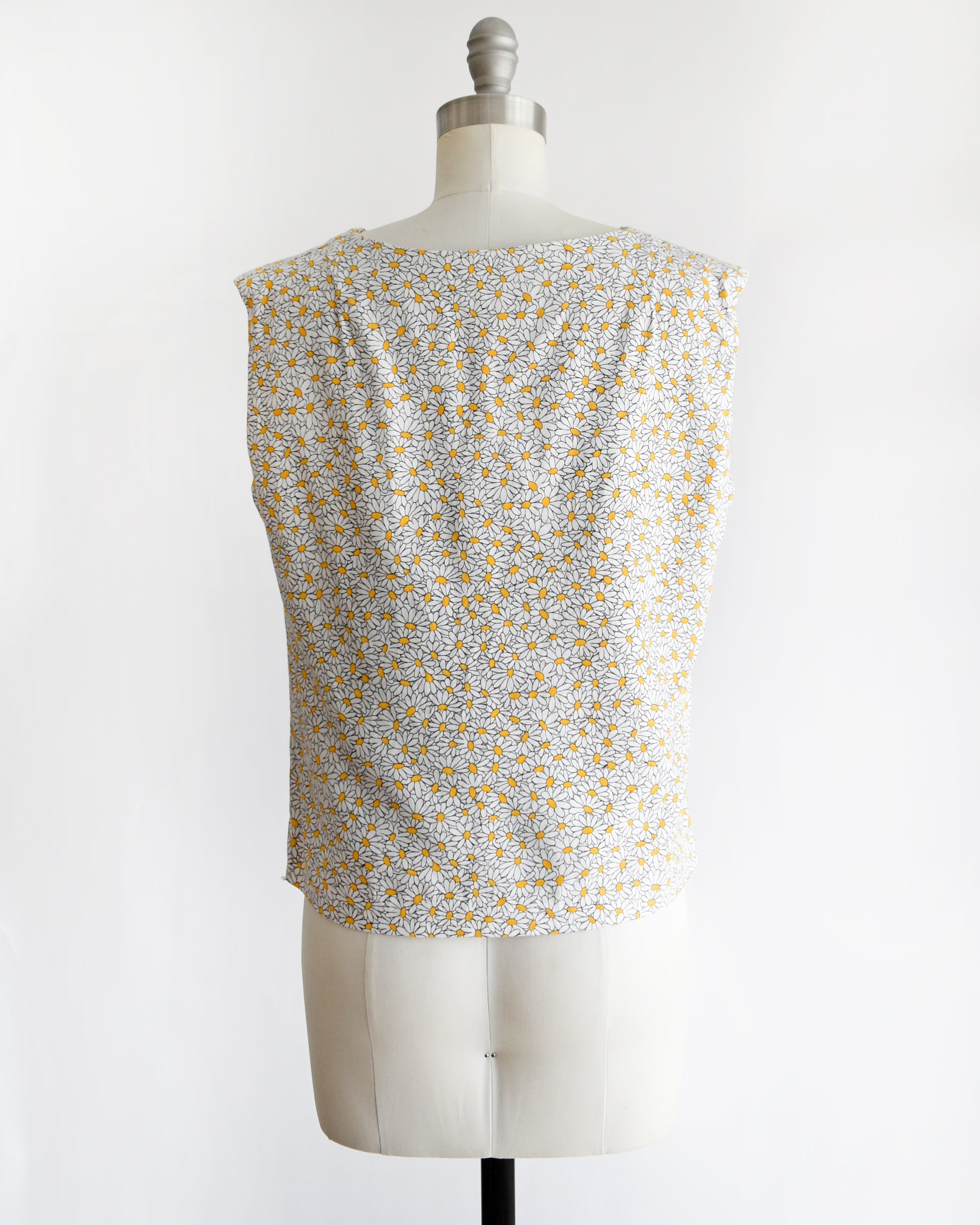 back view of a vintage floral sleeveless top on a mannequin against a white background