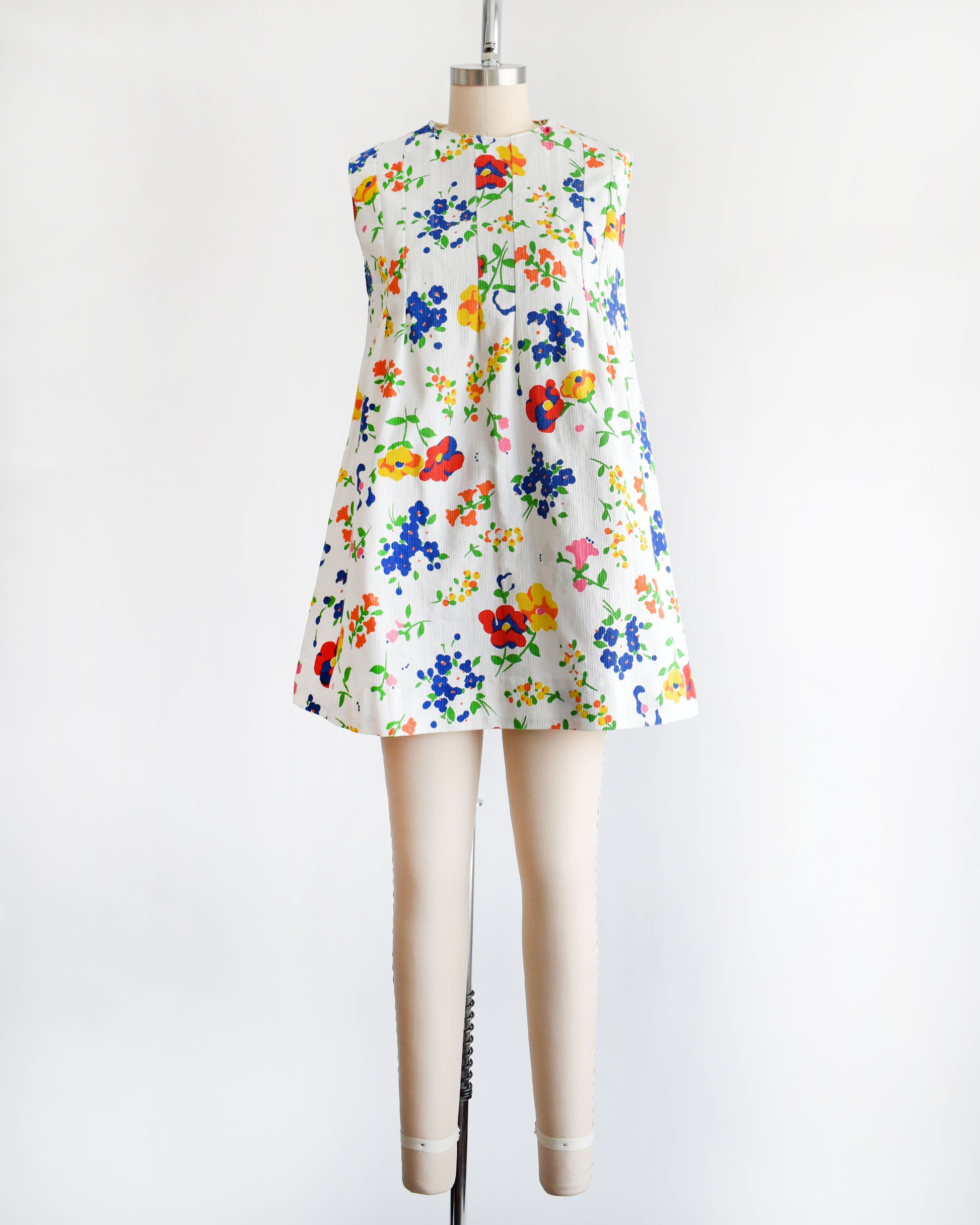 a vintage 1960s floral dress on a mannequin against a white background