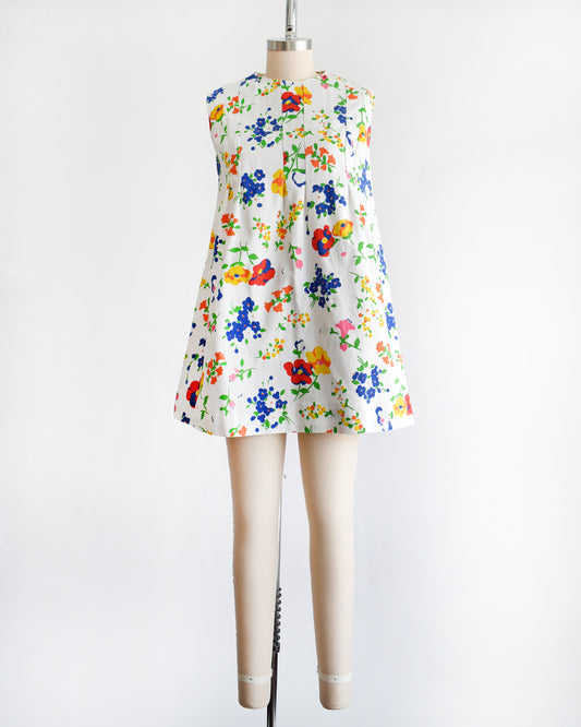 a vintage 1960s floral dress on a mannequin against a white background