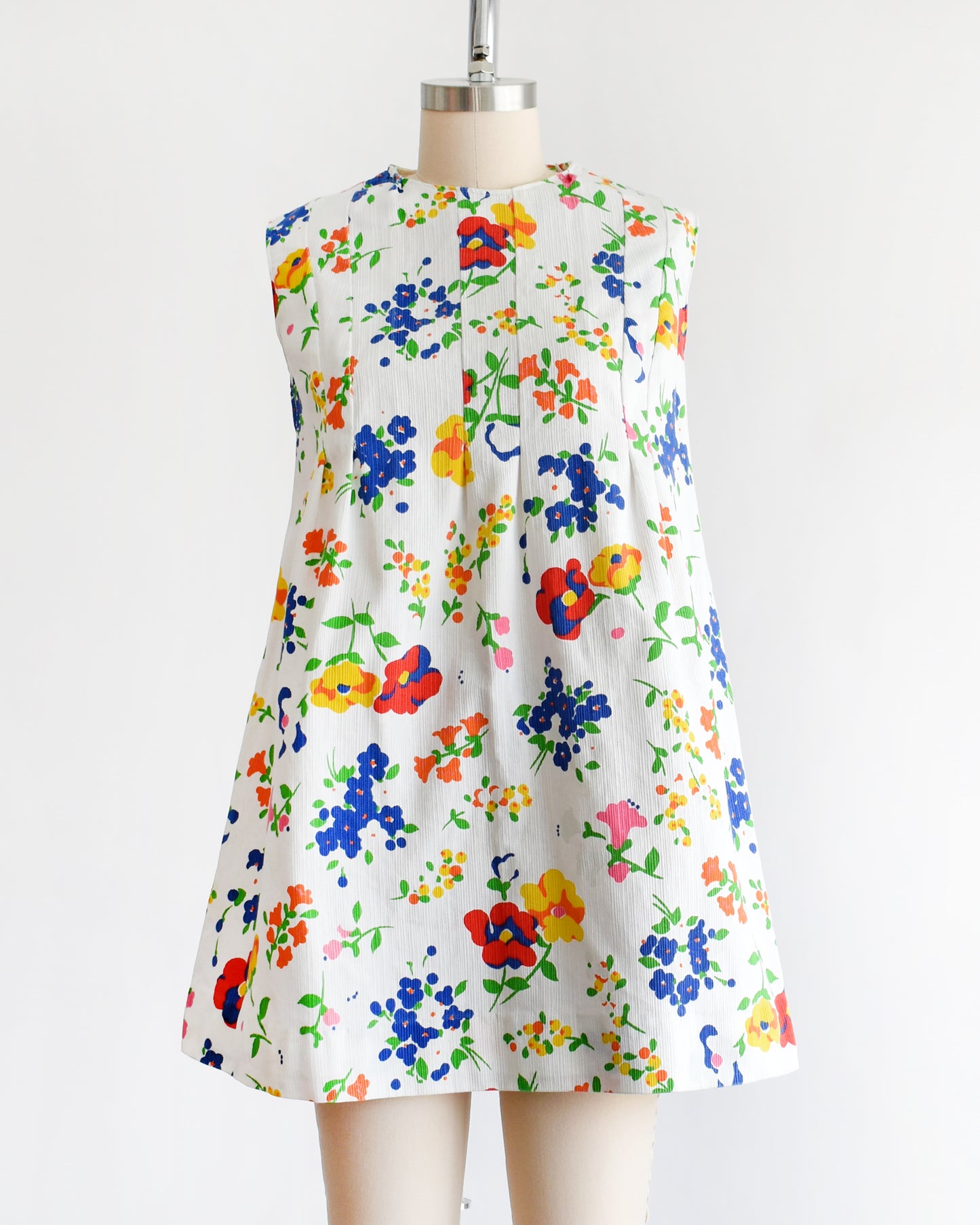 a vintage 1960s floral dress on a mannequin against a white background