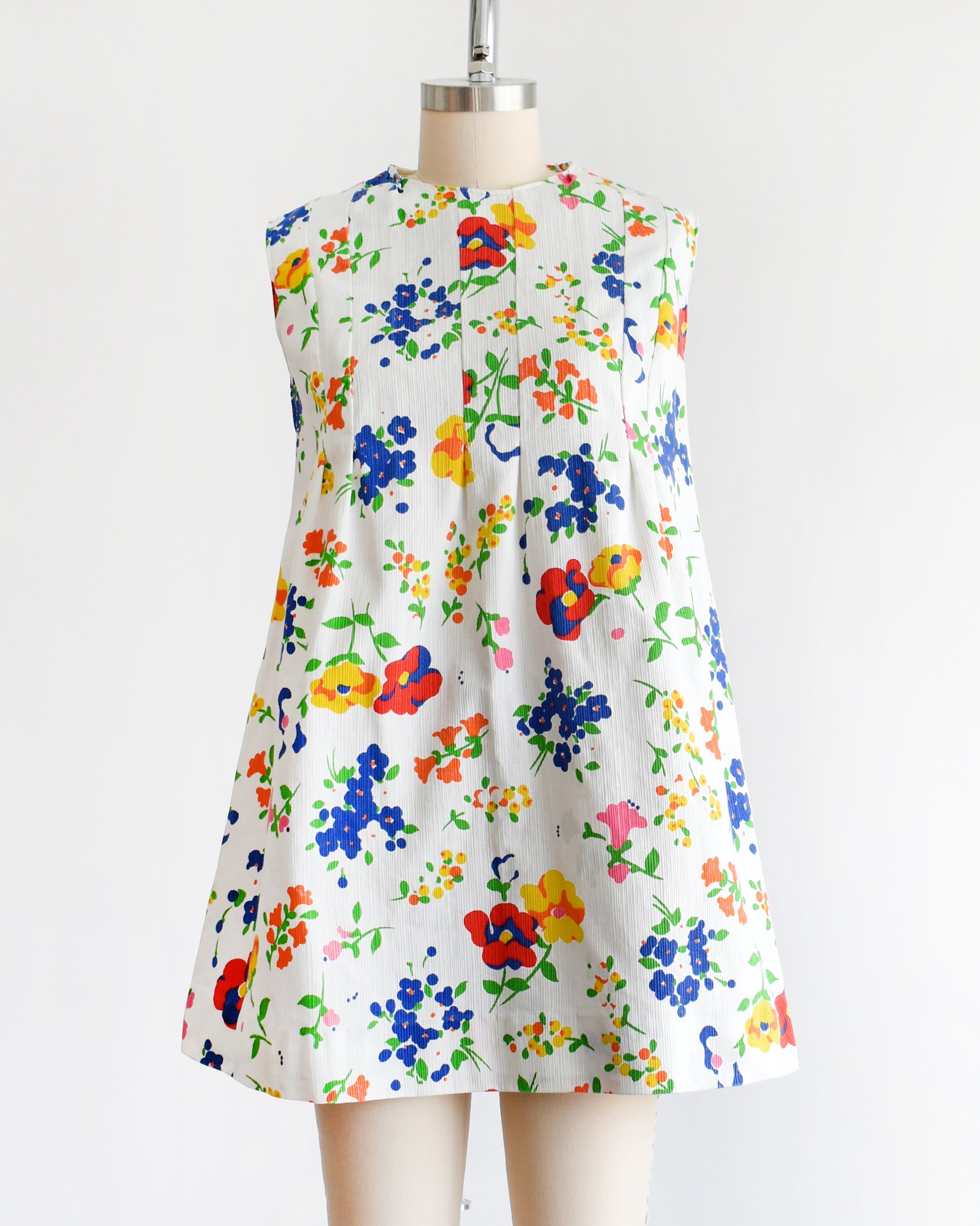 a vintage 1960s floral dress on a mannequin against a white background