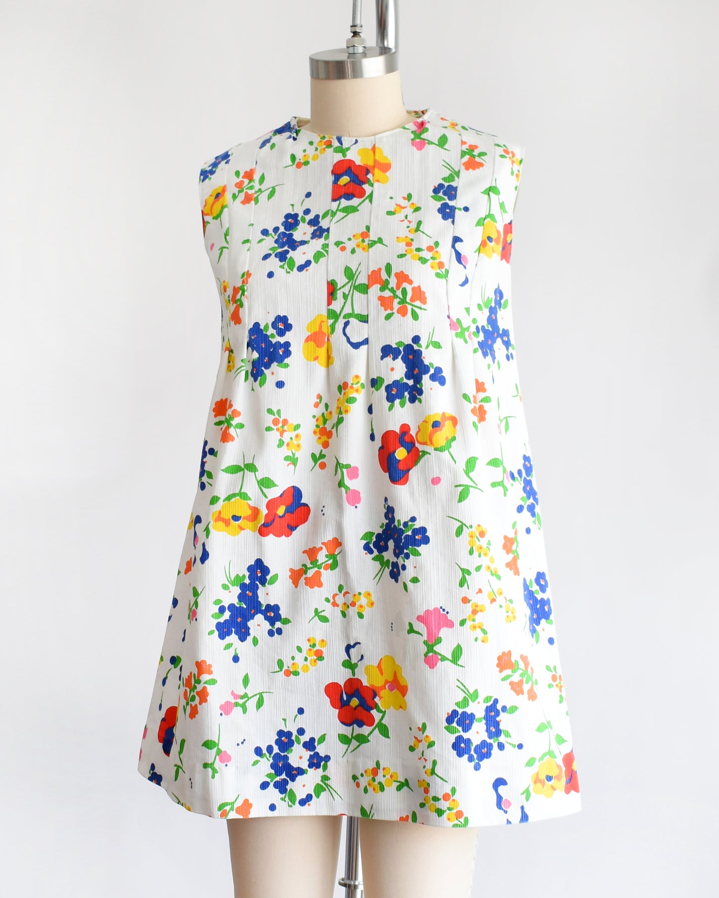 side front view of a vintage 1960s floral dress on a mannequin against a white background