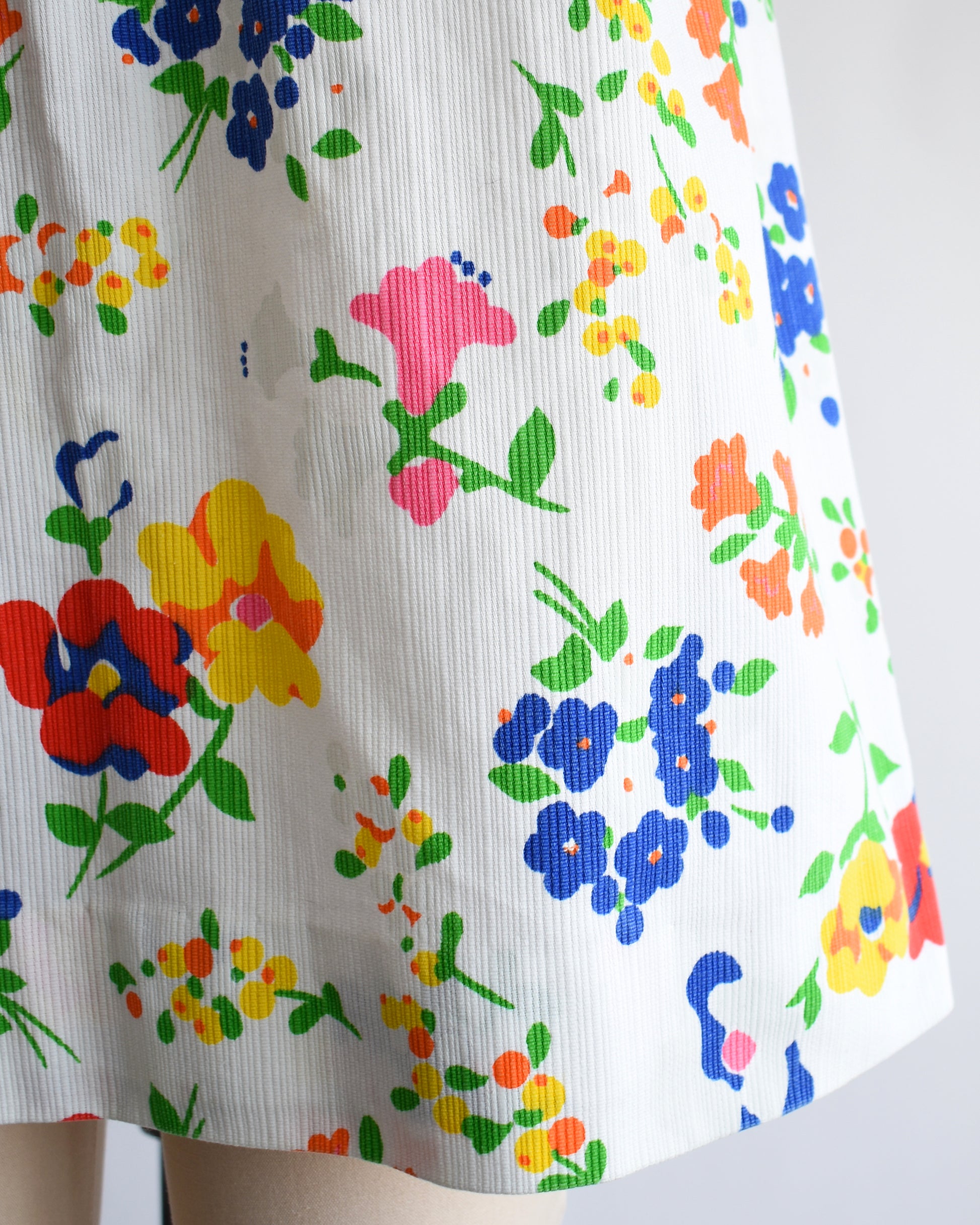 close up of a vintage 1960s floral dress on a mannequin against a white background