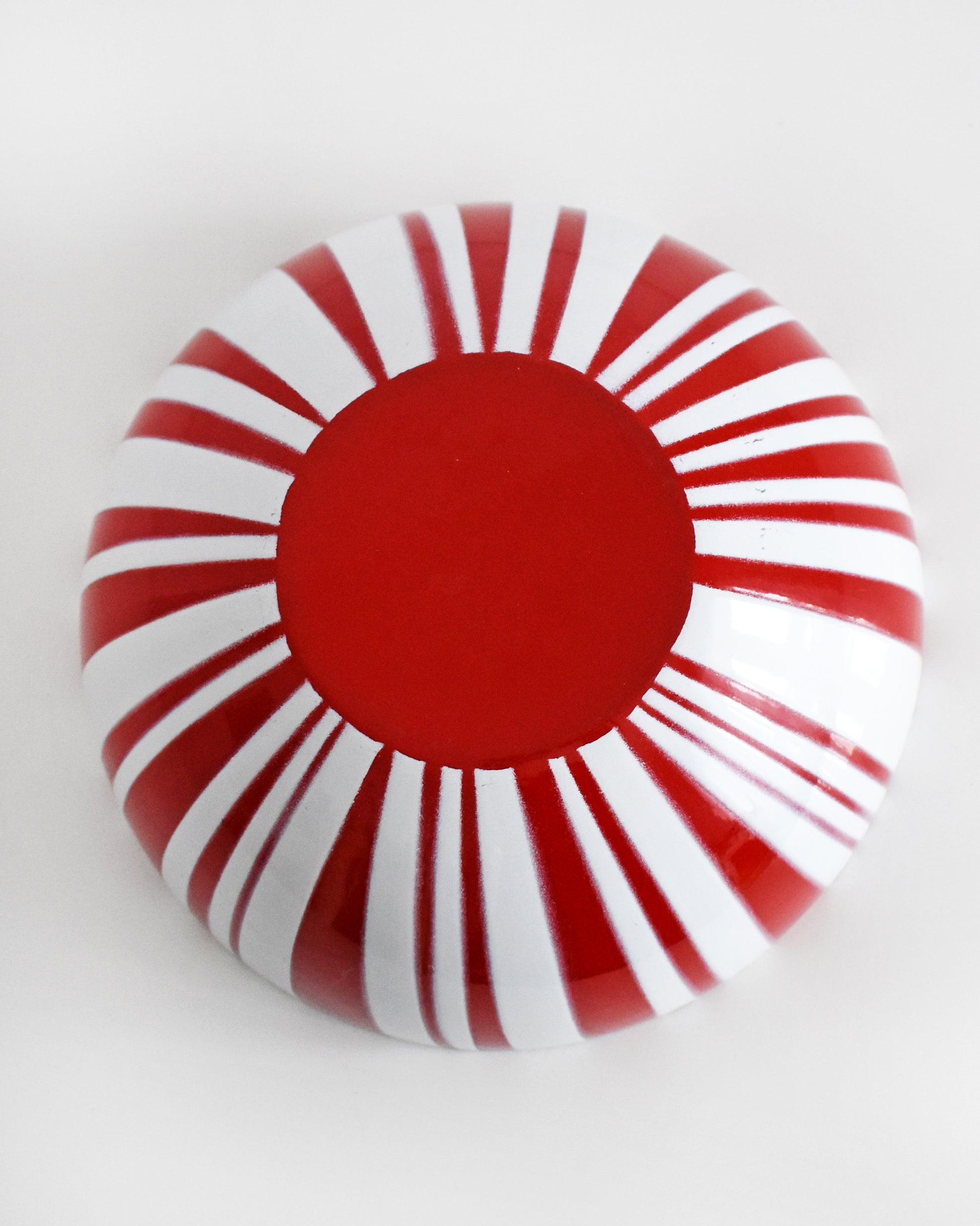 overhead shot of the bottom of a vintage red and white striped Cathrineholm bowl on a white background