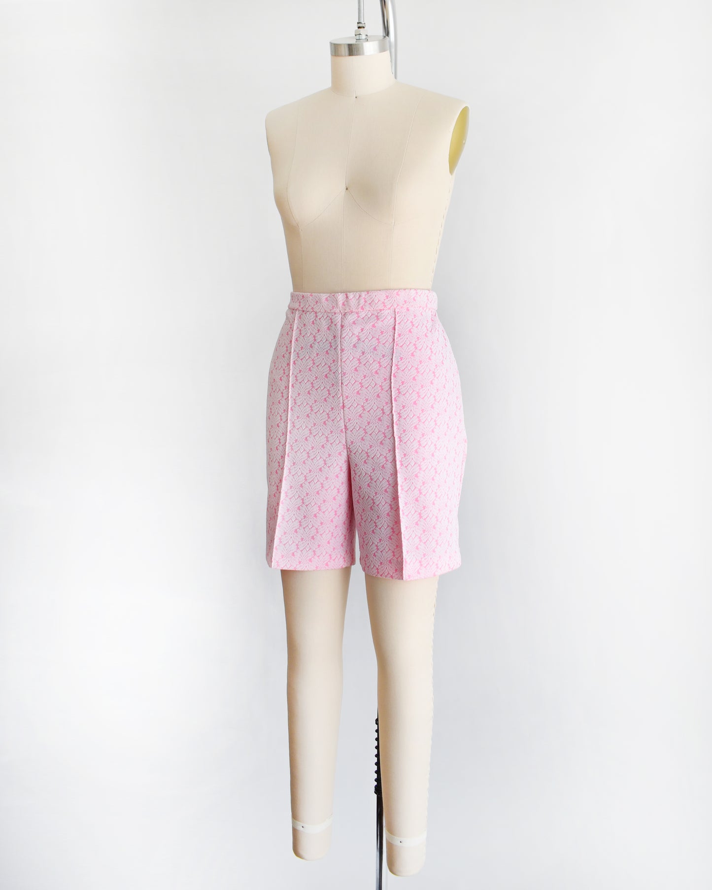 side front view of vintage 70s pink and white shorts on a mannequin against a white background
