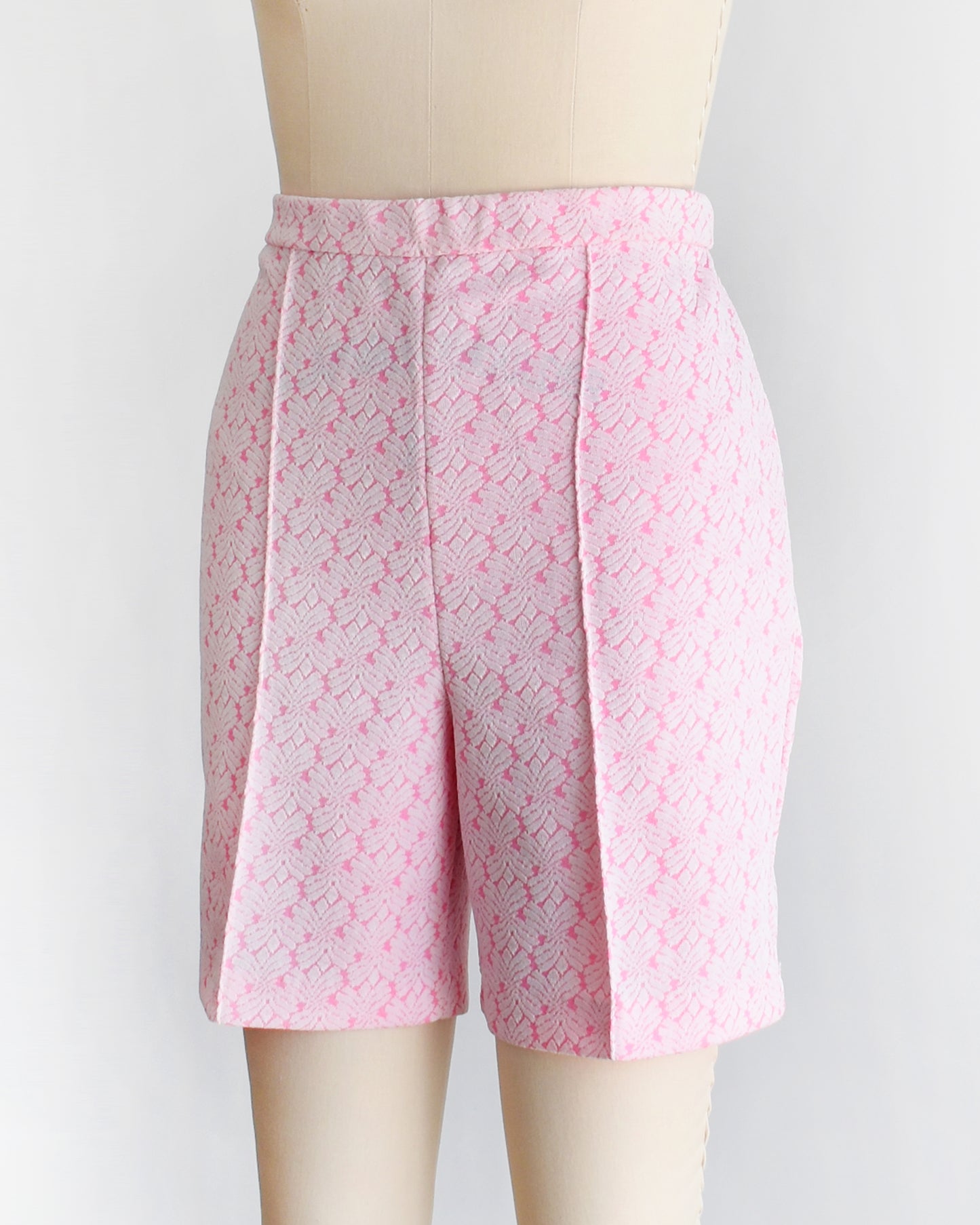 side front view of vintage 70s pink and white shorts on a mannequin against a white background