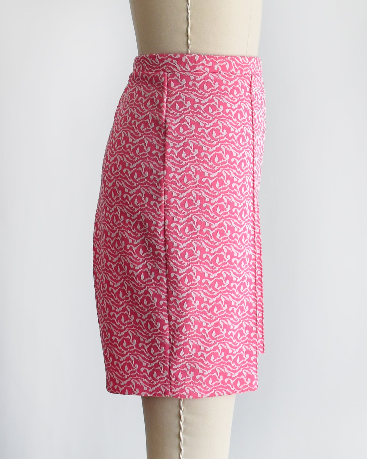 side view of vintage 70s pink and white shorts on a mannequin against a white background