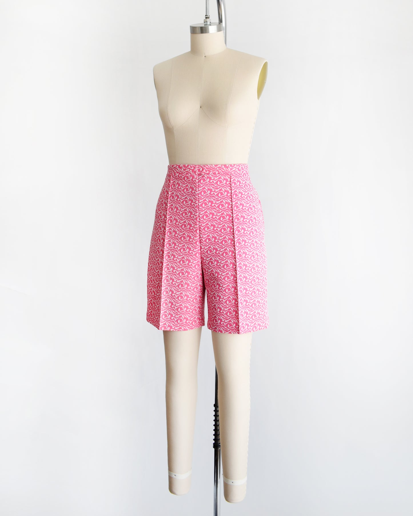 side front view of vintage 70s pink and white shorts on a mannequin against a white background