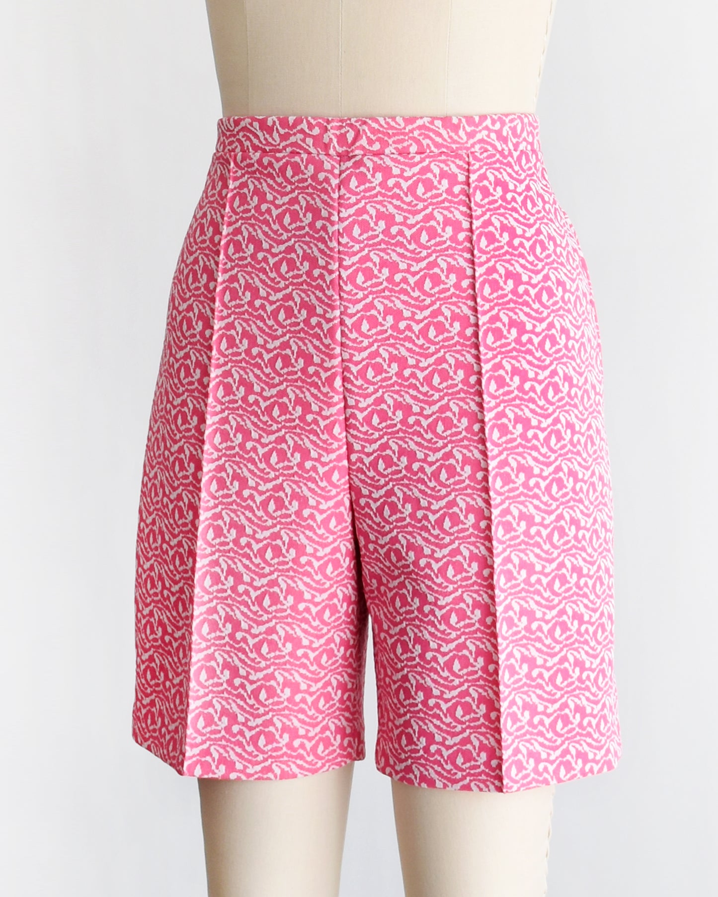 side front view of vintage 70s pink and white shorts on a mannequin against a white background