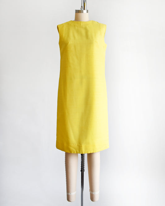 a vintage 1960s yellow shift dress on a dress form
