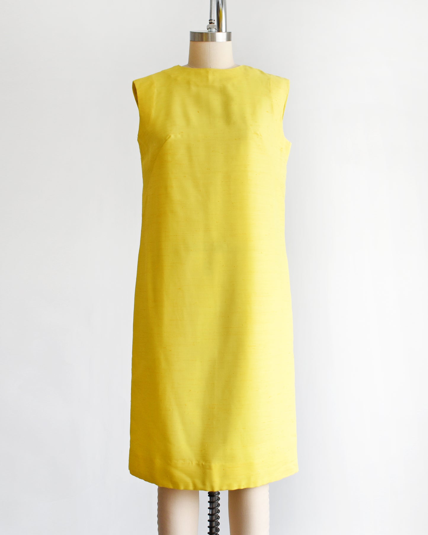 a vintage 1960s yellow shift dress on a dress form