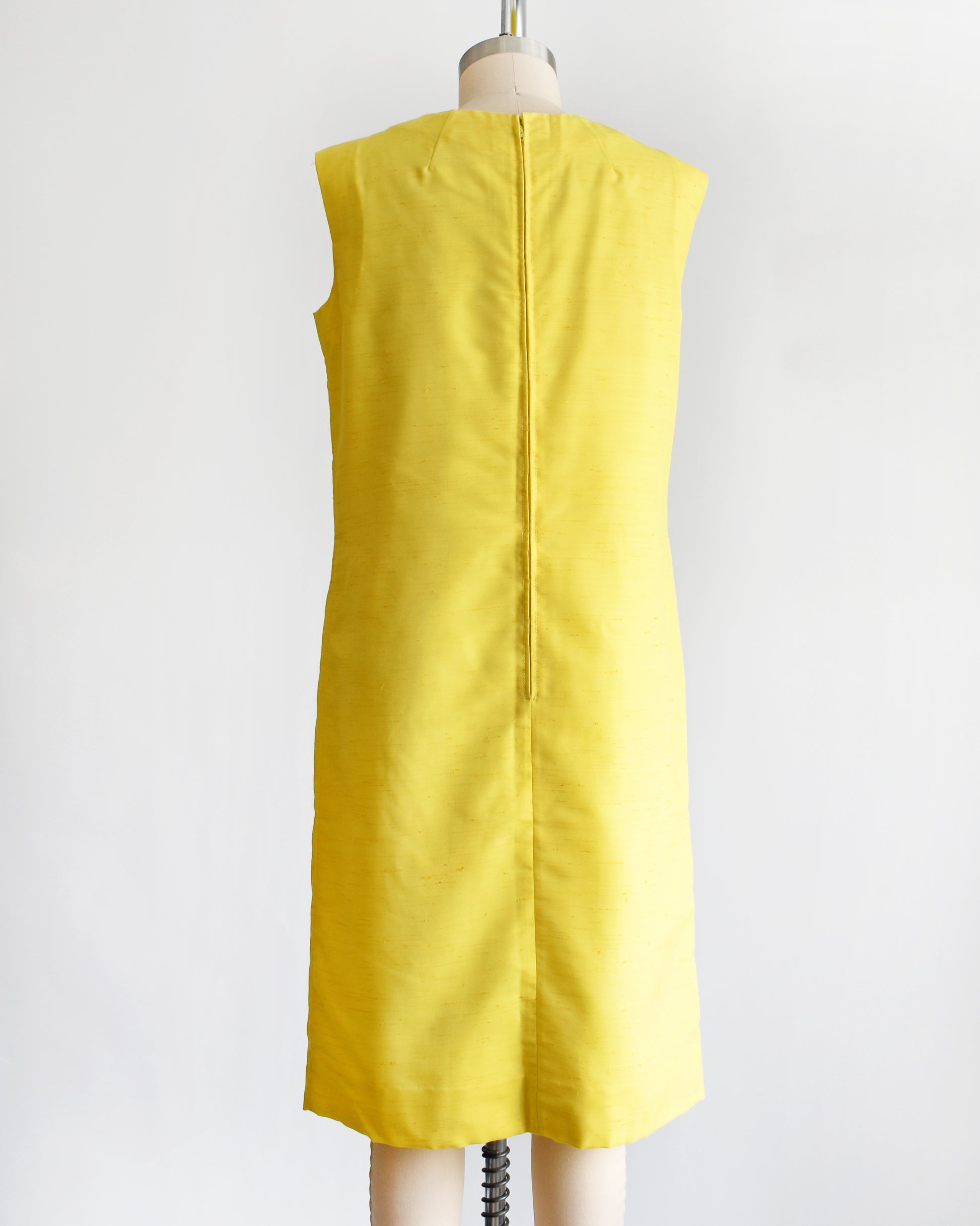 back view of a vintage 1960s yellow shift dress on a dress form