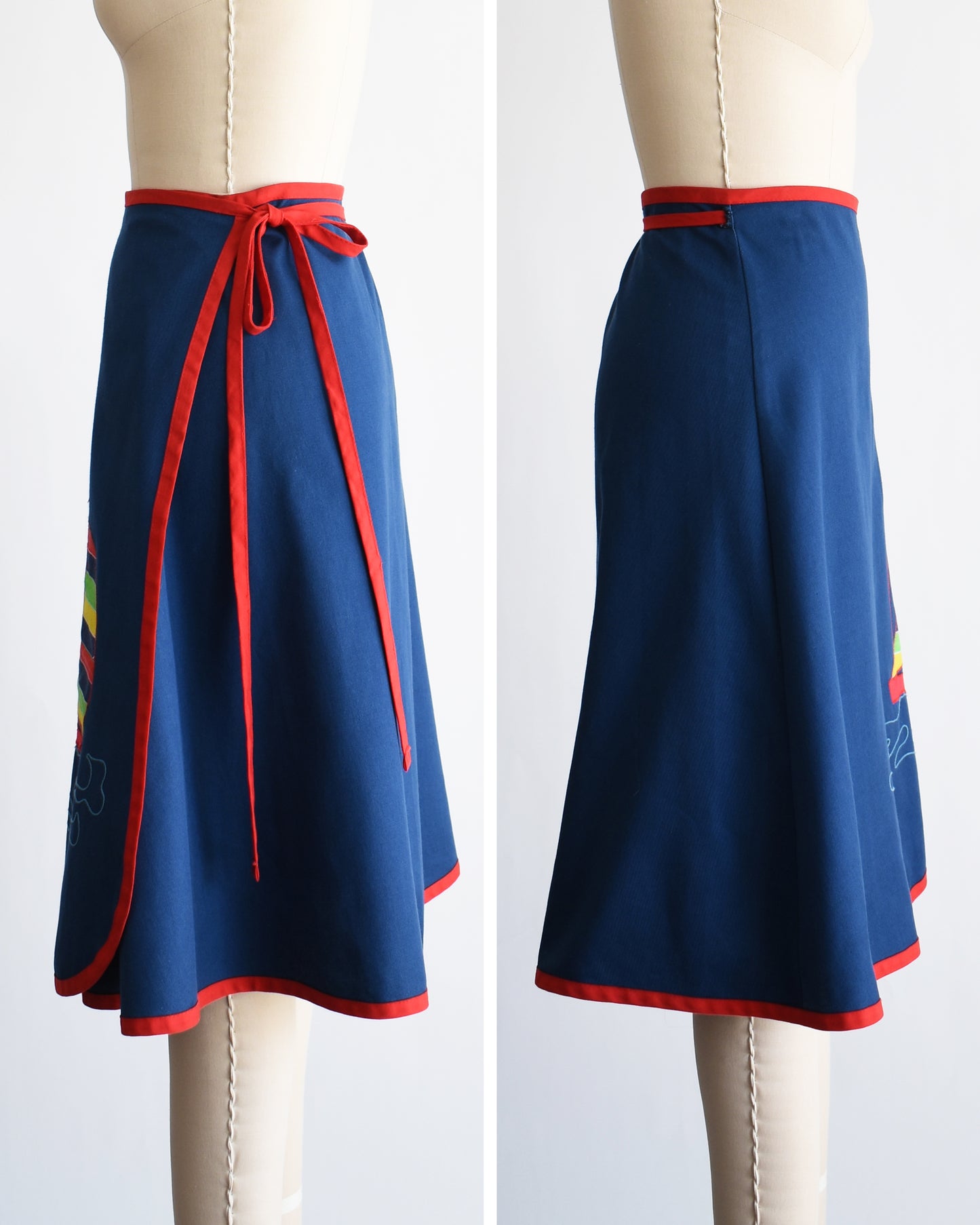 side by side side views of a vintage blue wrap skirt with a colorful sailboat design on a mannequin against a white background