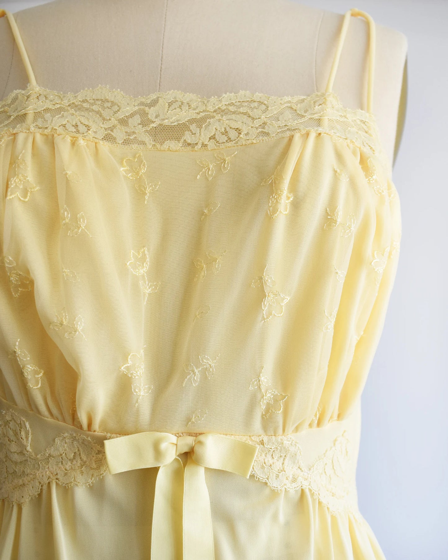 Close up of the lace trim, floral embroidery, and ribbon on the nightgown