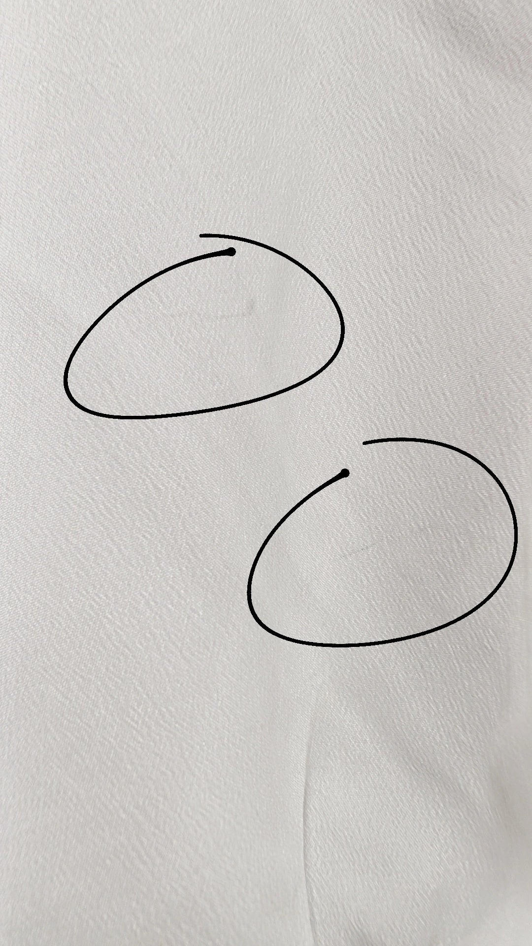 A few gray marks on the left sleeve that are circled 
