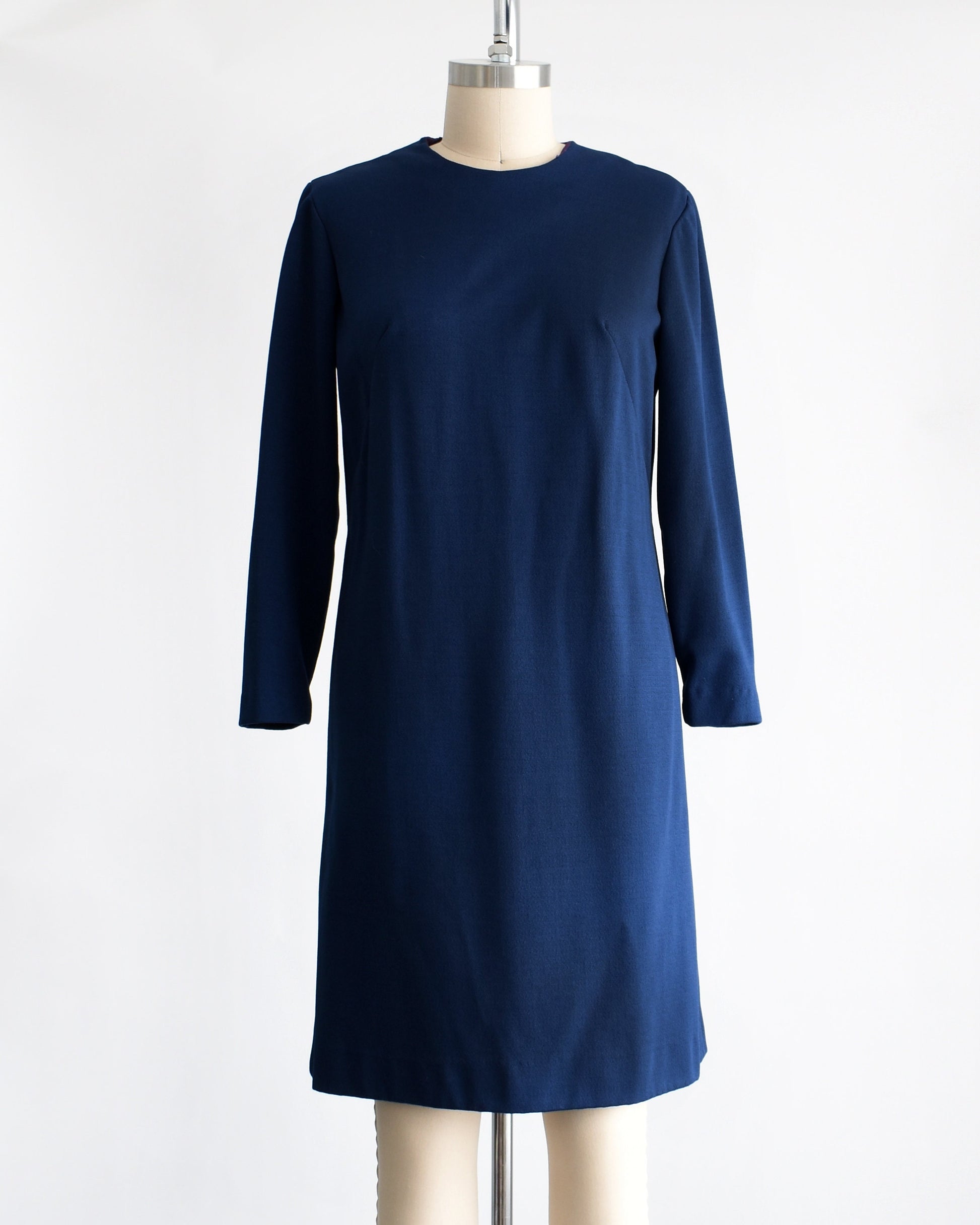 A vintage 60s/70s long sleeve navy blue dress. Dress is modeled on a dress form.