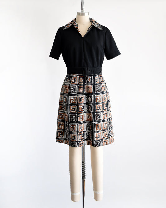 A vintage 60s dress that has a matching geometric print brown, black and white collar and skirt. Zip up front which is zipped down to expose more of the collar. Matching black belt. Short sleeves. The dress is on a dress form.
